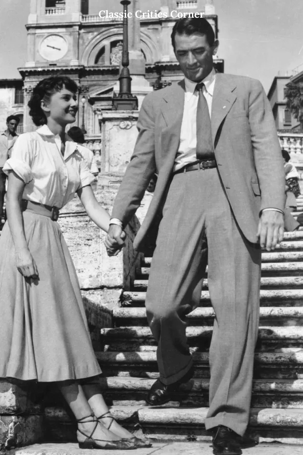 Audrey Hepburn shoe style highlighted from her iconic outfit in Roman Holiday, where she is wearing strappy flat sandals, while out with Gregory Peck
