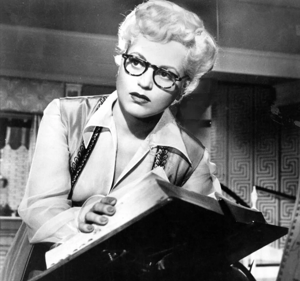 Image of Judy Holliday wearing glasses in Born Yesterday